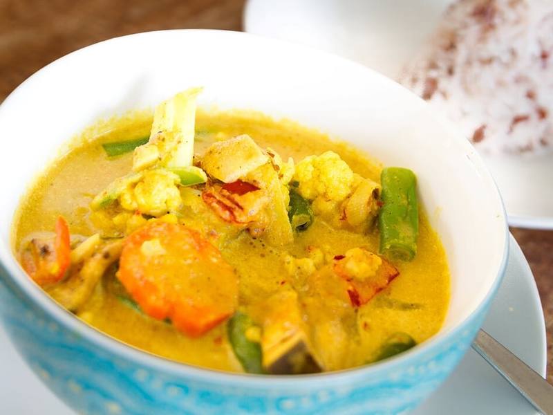 A bowl of Balinese yellow curry with vegetables