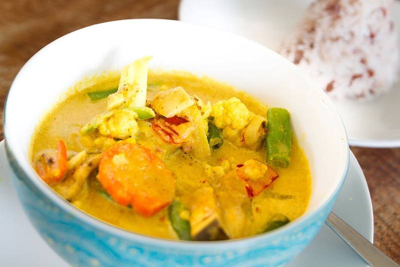 A bowl of Balinese yellow curry with vegetables
