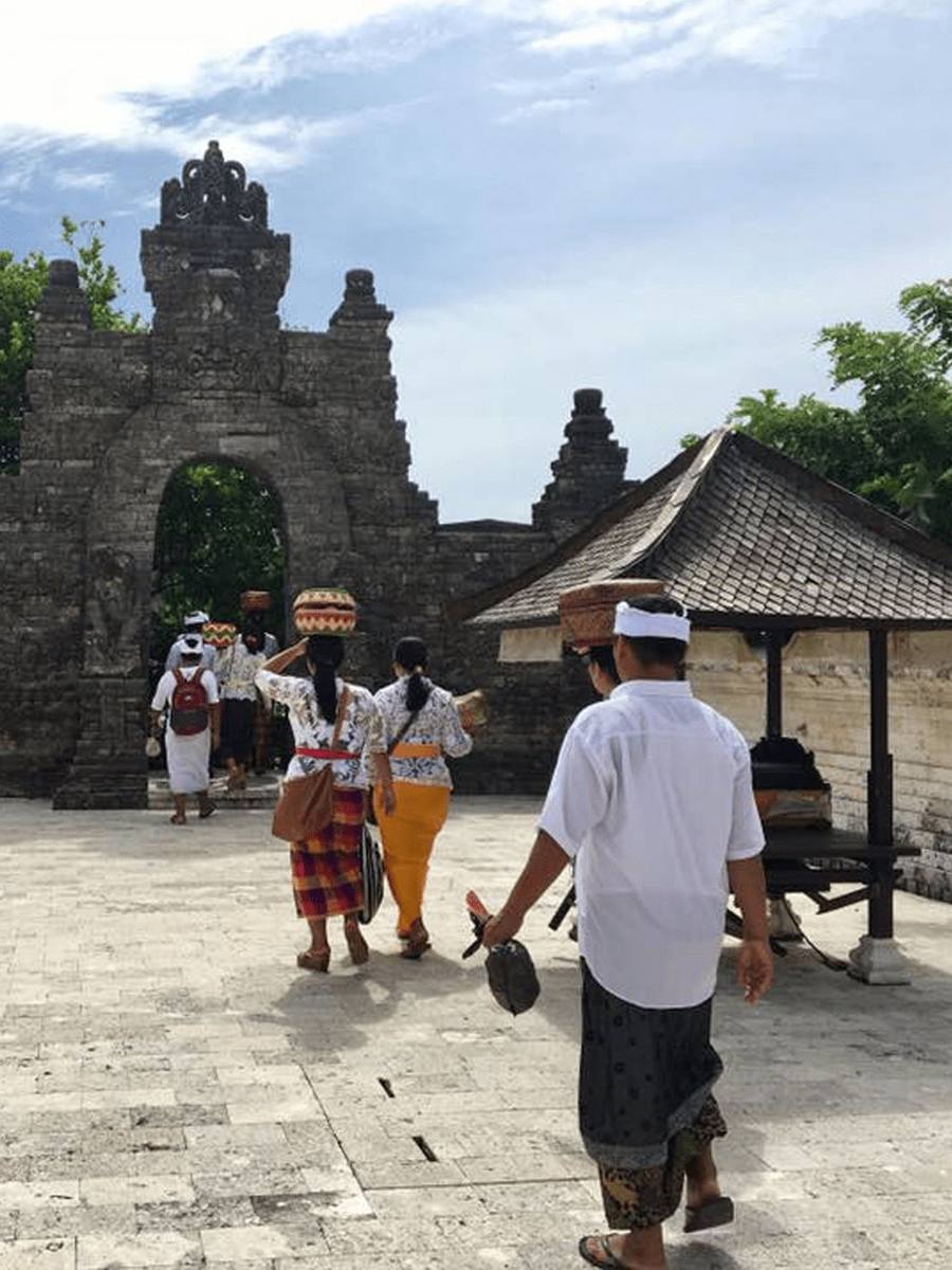 Balinese villagers in traditional dress walking to a temple ceremony