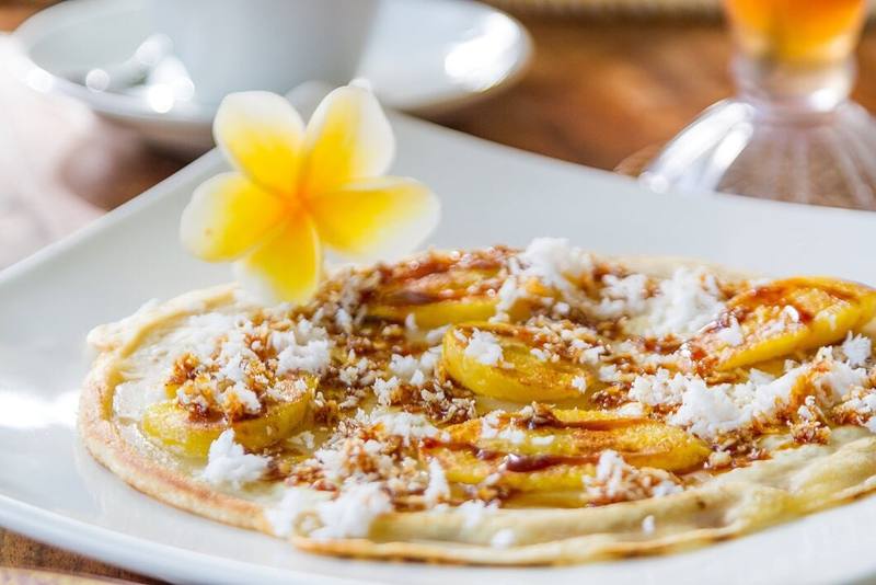 A banana pancake with coconut and a frangipani flower
