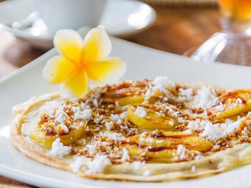 A banana pancake with coconut and a frangipani flower