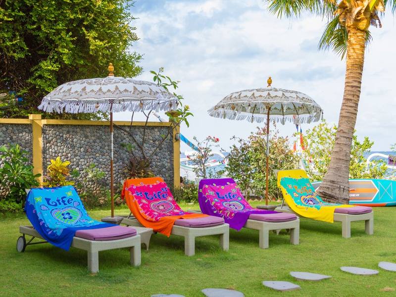 Colourful loungers and parasols on the lawn by the beach