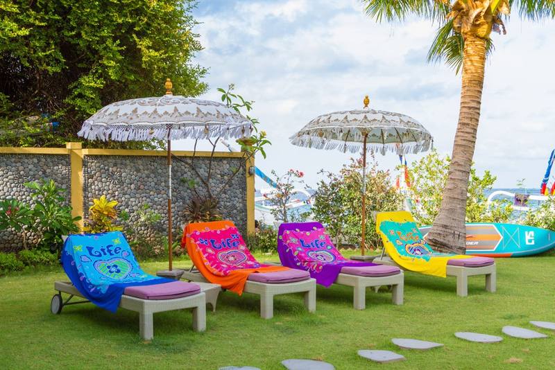 Colourful loungers and parasols on the lawn by the beach