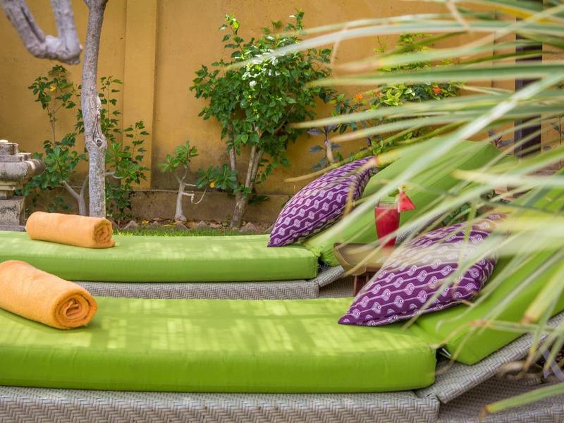 Green loungers with purple cushions on a villa terrace