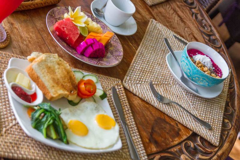 Breakfast table with tropical fruit, eggs and coffee