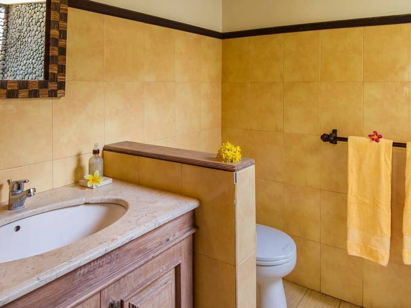 Natural-stone bathroom with yellow walls in a Beach Cottage