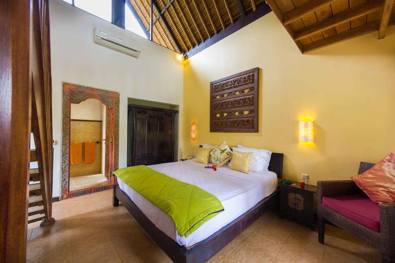 King-size bed with carved headboard art in a Beach Cottage at Life in Amed