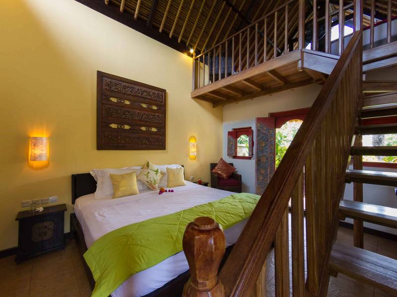 Beach Cottage bedroom with wooden stairs up to the loft