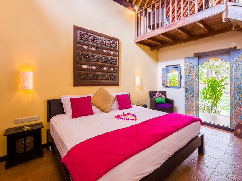 Beach Cottage bedroom with pink bedspread and doors open to the garden