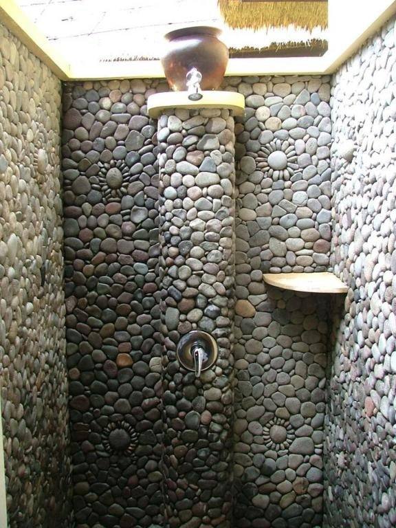 Pebble-stone open-air shower in a Beach Cottage