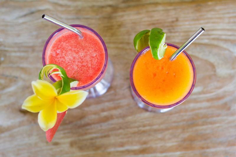 Two fresh tropical juices decorated with frangipani flowers