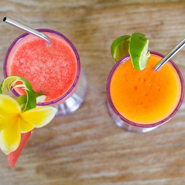 Two fresh tropical juices decorated with frangipani flowers