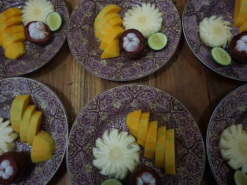 Plates of mango, mangosteen and pineapple on carved plates