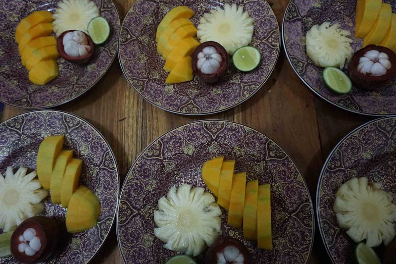 Plates of mango, mangosteen and pineapple on carved plates
