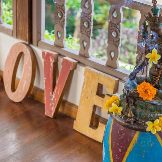 Colourful wooden LOVE letters and a flower-filled Ganesha in the garden