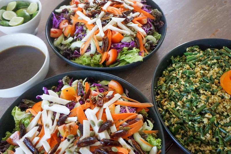 Colourful organic salads and a vegetable dish served family-style
