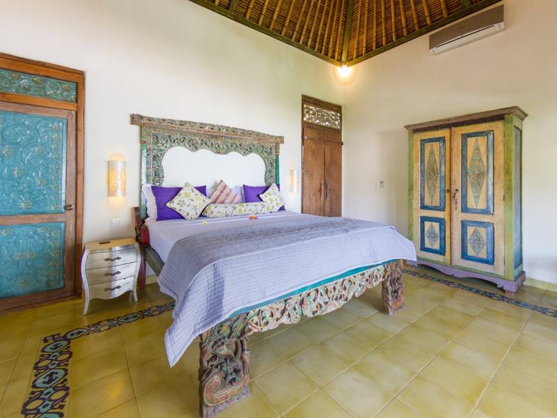 Perfumed Garden bedroom with carved bed and antique wardrobe