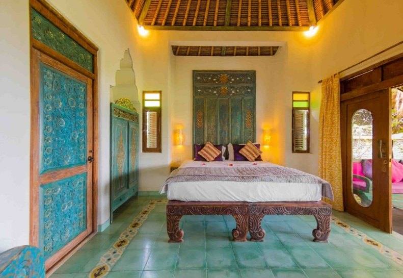 Perfumed Garden bedroom with carved king-size bed and blue painted doors