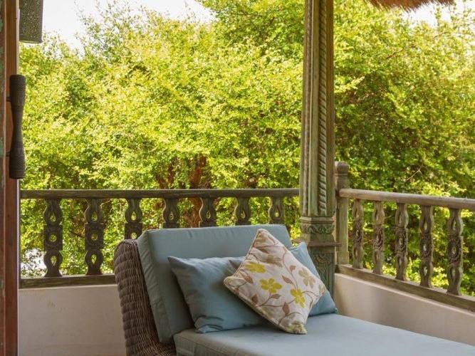 A daybed on the upper terrace of the Perfumed Garden among the trees