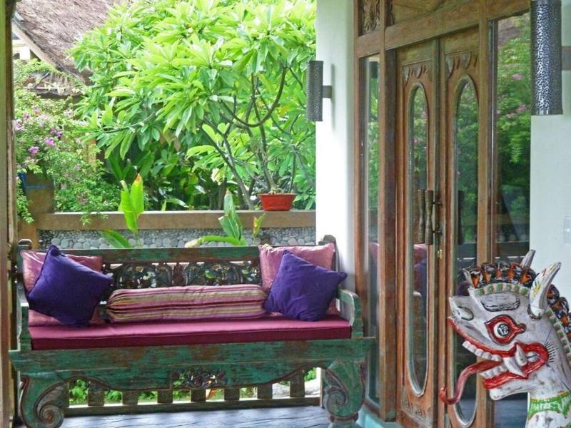 Carved daybed with purple cushions on a Perfumed Garden terrace
