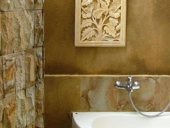 Stone bathroom with corner bathtub in Sari Sunrise Villa