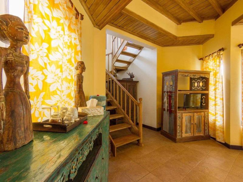 Lower level of Sari Sunrise Villa with a carved statue and stairs