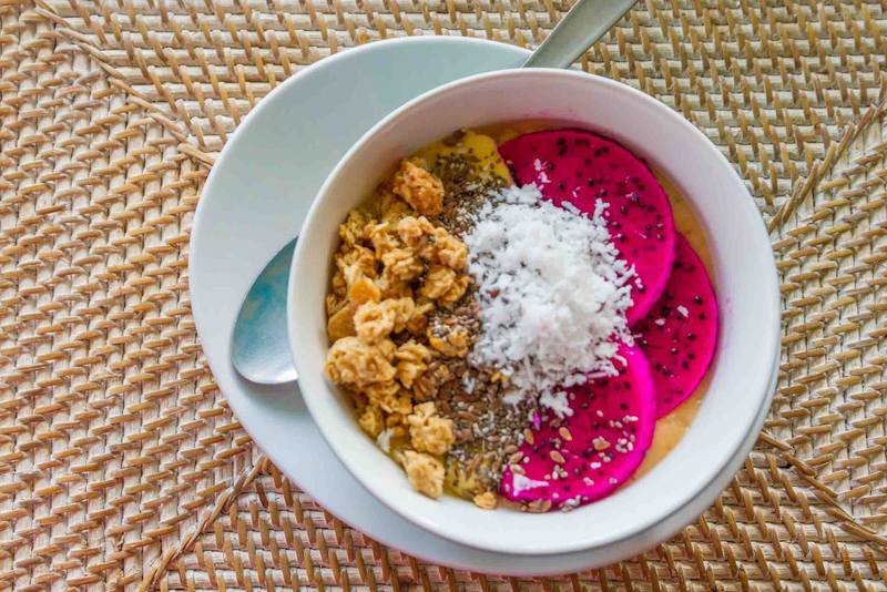 Smoothie bowl with dragon fruit, granola and coconut