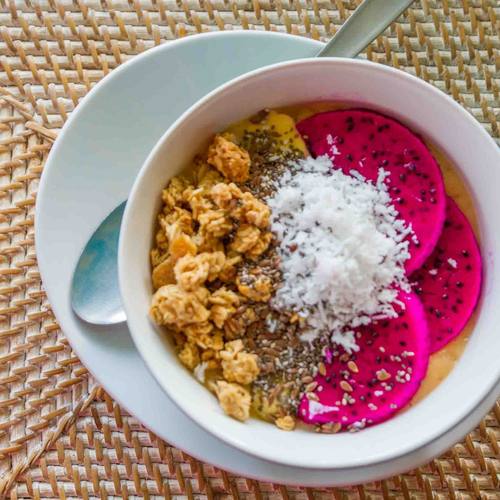 Smoothie bowl with dragon fruit, granola and coconut