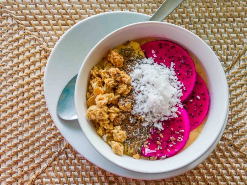 Smoothie bowl with dragon fruit, granola and coconut