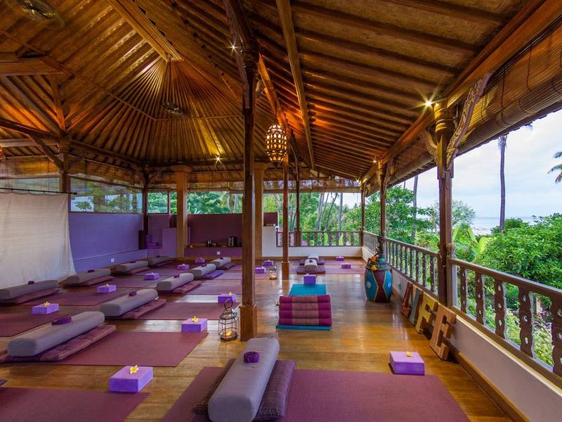 The open-sided, wooden-floored yoga shala at Life in Amed, surrounded by the tropical garden