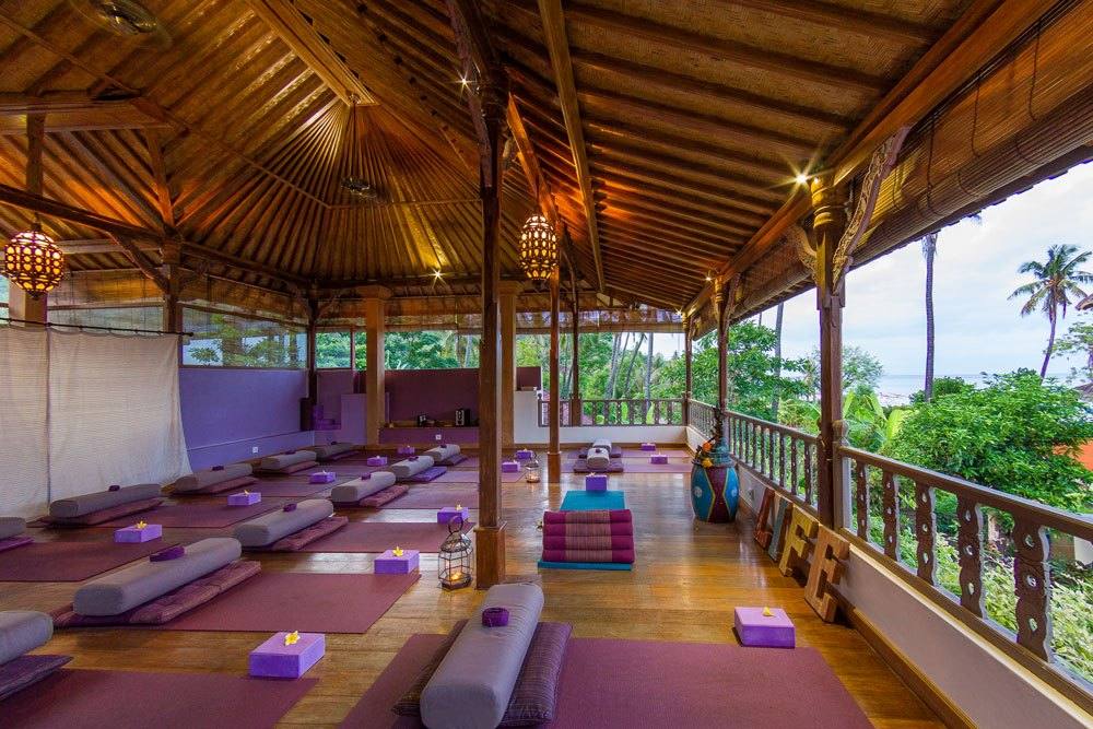 The open-sided, wooden-floored yoga shala at Life in Amed, surrounded by the tropical garden